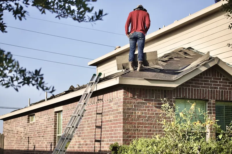 Professional roofer working on a residential roof in Raymondville